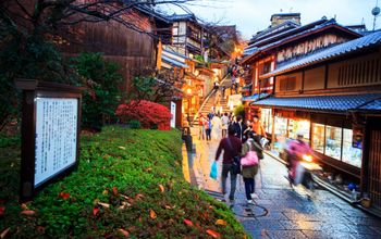 Tourists walk on a street leading to Kiyomizu-dera Temple in Kyoto, Japan