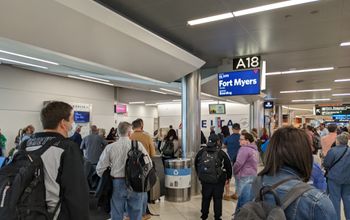 Airport crowd gathers at gate to board flight